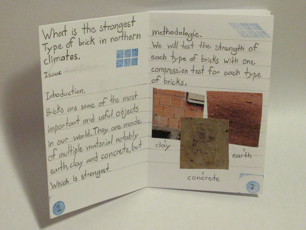 Paper zine open in the midle, text about construction materials and collage is presentation.